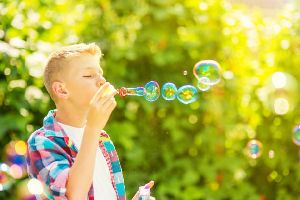 istock Portrait of a young boy blowing soap bubbles 1082907290