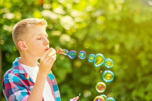 istock Portrait of a young boy blowing soap bubbles 1082907492