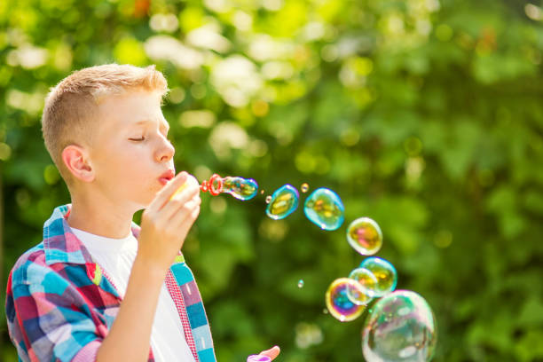 istock Portrait of a young boy blowing soap bubbles 1082907532