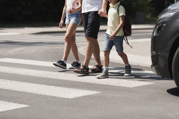 niños cruzando la calle con su padre - pedestrian fotografías e imágenes de stock