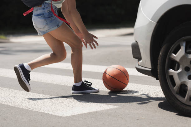 Young girl catching a basket ball on a pedestrian crossing Young girl catching a basket ball on a pedestrian crossing zebra photos stock pictures, royalty-free photos & images