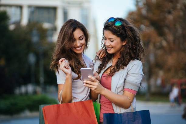 istock Best friends resting after shopping and using smart phone 1082915122