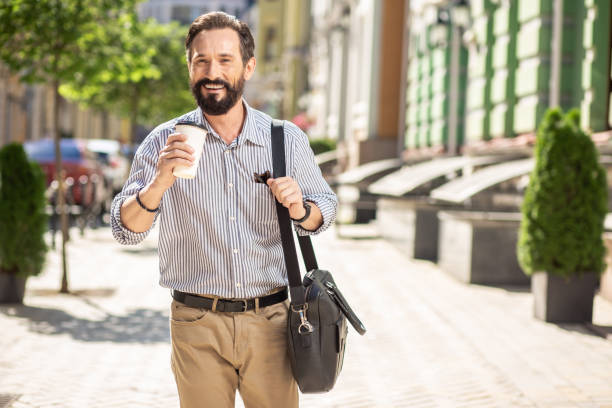 istock Joyful handsome man drinking coffee in the morning 1082921384