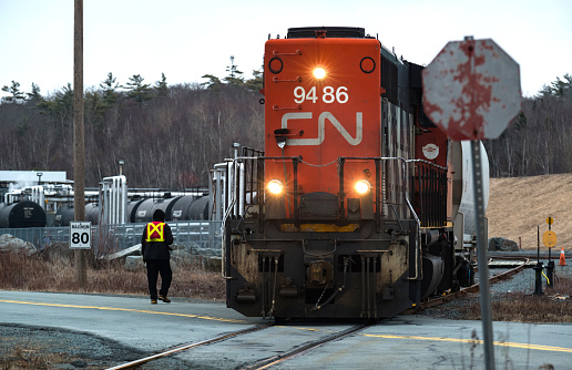 Bedford, Canada - March 21, 2014 - A CN Rail engineer oversees a diesel locomotive reversing into a asphalt/sealant processing facility.