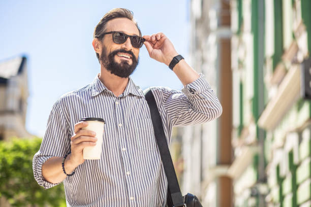 istock Joyful bearded man drinking coffee on the street 1082922676