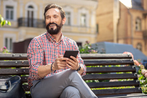 istock Joyful adult man resting on the bench 1082923074