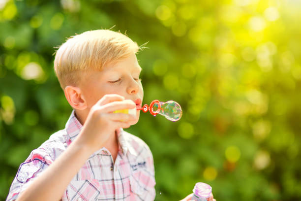 istock Portrait of a young boy blowing soap bubbles 1082924710