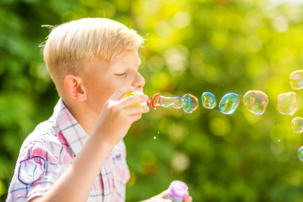 istock Portrait of a young boy blowing soap bubbles 1082924808