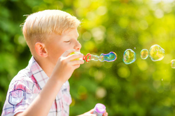 istock Portrait of a young boy blowing soap bubbles 1082925010