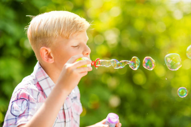 istock Portrait of a young boy blowing soap bubbles 1082925046