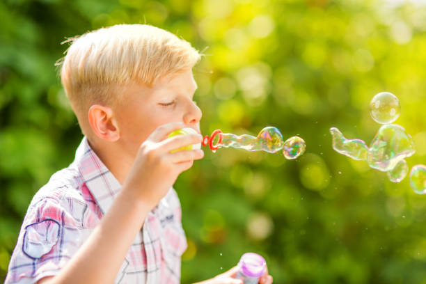 istock Portrait of a young boy blowing soap bubbles 1082925050