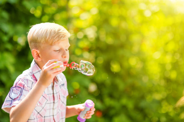 istock Portrait of a young boy blowing soap bubbles 1082925218