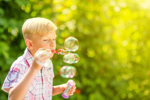 istock Portrait of a young boy blowing soap bubbles 1082925220