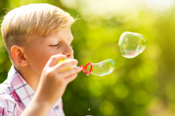 istock Portrait of a young boy blowing soap bubbles 1082925308