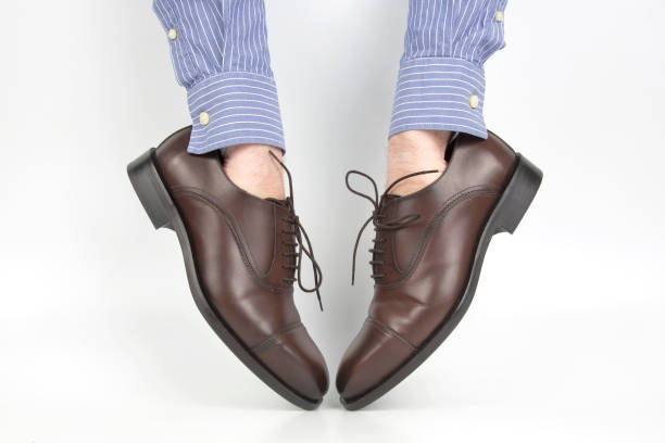 istock Classic brown shoes worn on the hands on a white background 1082928216