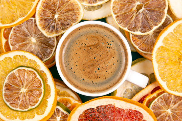 Black coffee in a white Cup surrounded by citrus dried fruits