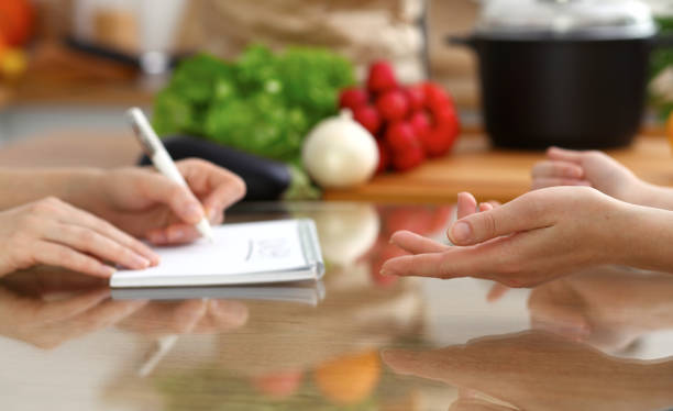 istock Closeup of human hands discussing something while cooking in kitchen. Women talking about menu. Family dinner, friendship and lifestyle concept. 1082928766