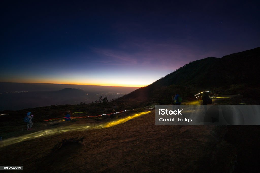 Ijen Crater volcano with a sunset, Banyuwangi, Indonesia Banyuwangi, Indonesia - August 13, 2018: tourists in the mountain with view of Kawah Ijen volcano with a sunset 2010-2019 Stock Photo