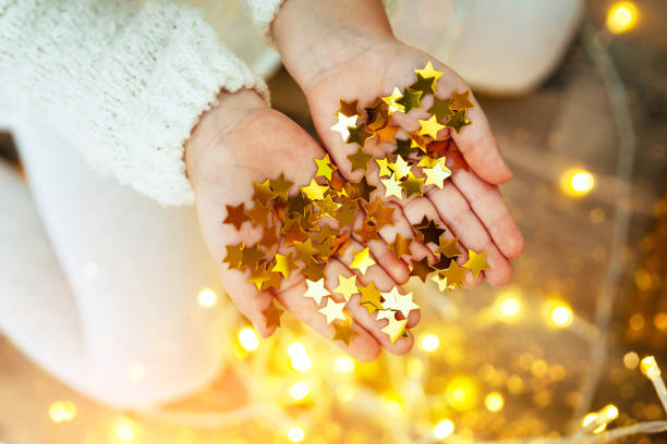 Golden stars sparkling on child's hands and palms.