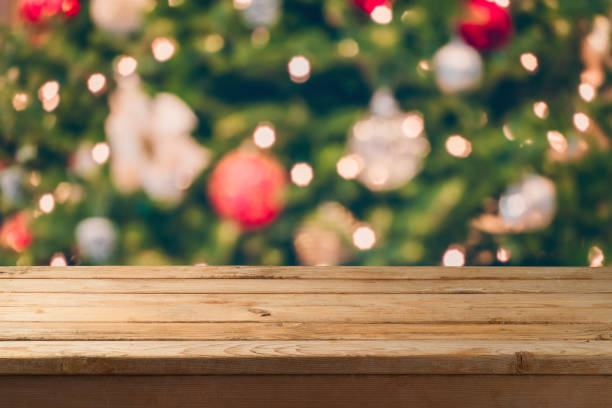 istock Christmas background with empty wooden table over festive bokeh Christmas tree decorations. 1082937504