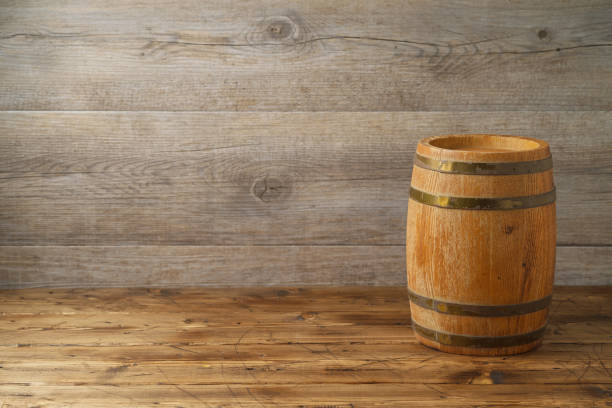 istock Empty wooden table with wine barrel over wooden board background 1082937508