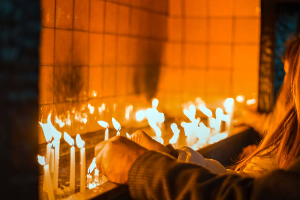 istock Hand lighting candles in a church 1082938370