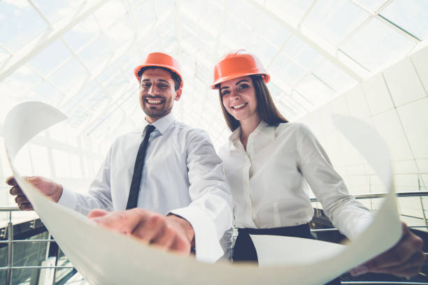 istock The two builders in a helmets hold the project plan in the building 1082948142