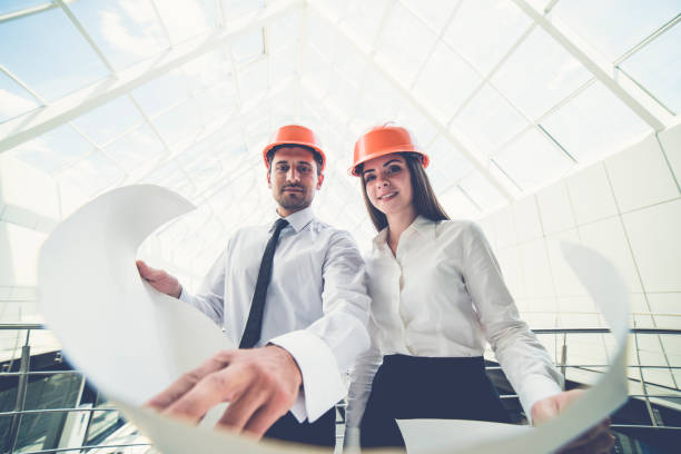 istock The two builders in a helmets hold the project plan in the building 1082948538