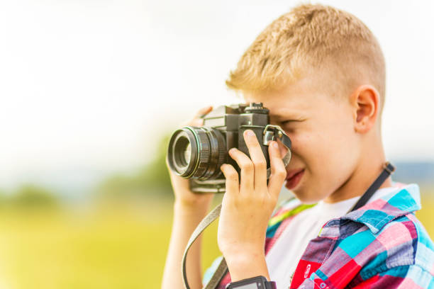 istock Young blonde boy holding a camera 1082951306