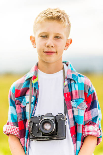 istock Young blonde boy holding a camera 1082952184