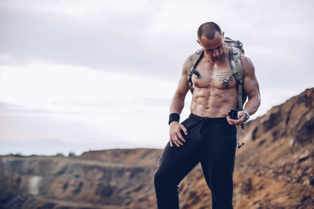 istock Strong man standing on the cliff and holding navigational compass 1082955406