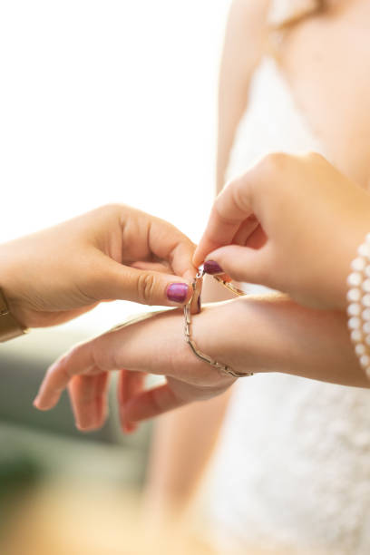 istock hands helping to put a bracelet on a bride 1082961392