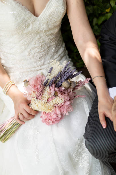 istock bride and groom holding hands on a park 1082961908