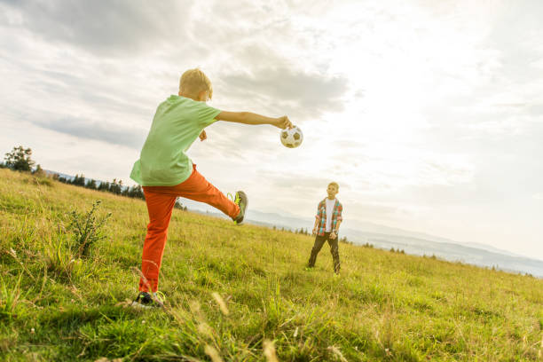 istock Boys playing football in a meadow, having fun 1082963456