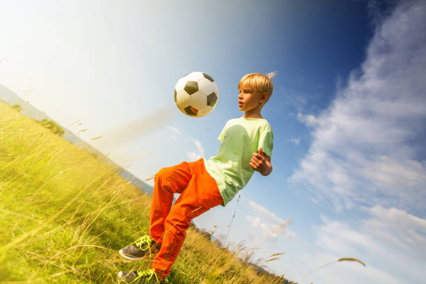 istock Boy playing football in a meadow, having fun 1082968980