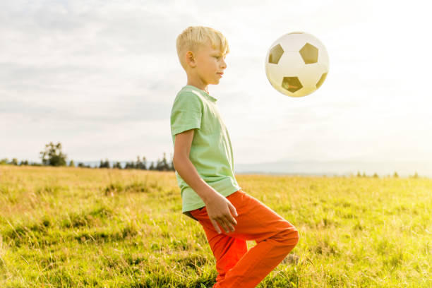 istock Boy playing football in a meadow, having fun 1082969806