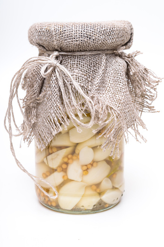 Canned pickled garlic in glass jar, Marinated garlic with koriander, healthy food