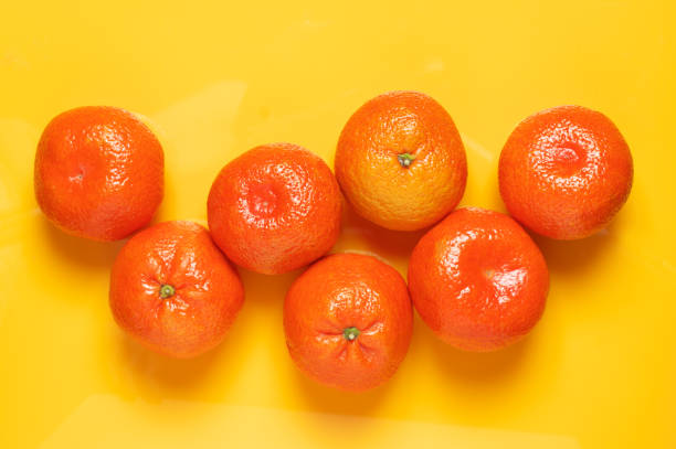 istock Tangerines on yellow background 1082990040
