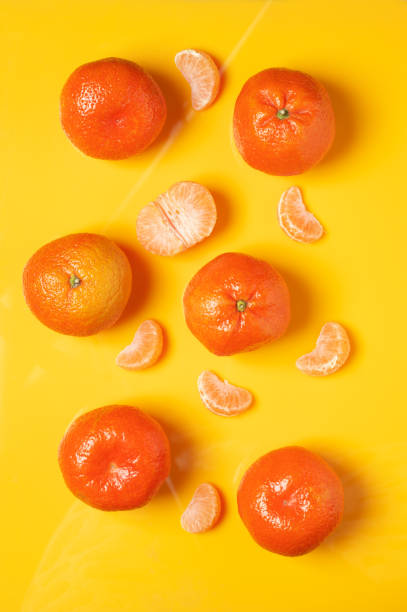 istock Tangerines on yellow background 1082990076