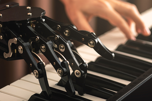 Concepts of prosthetics or artificial intelligence. Human with neural hand prosthesis playing piano