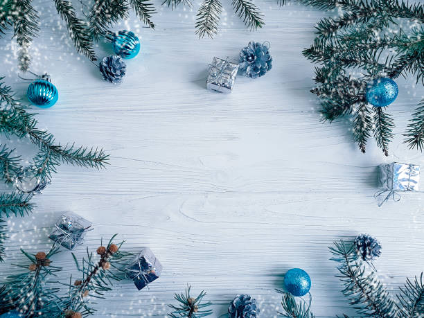 istock Christmas tree branch, blue ball, gift, cone on white wooden background 1083002248