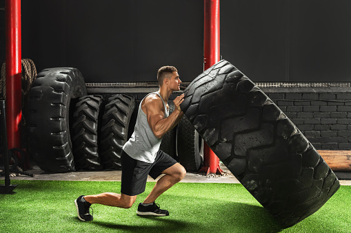 Tire flip exercise. Strong sportsman during his cross training workout.