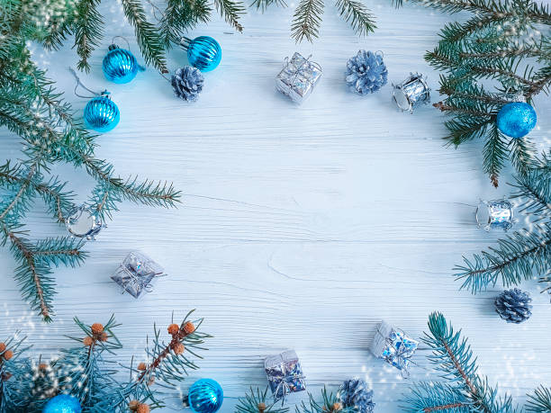 istock Christmas tree branch, blue ball, gift, cone on white wooden background 1083005348
