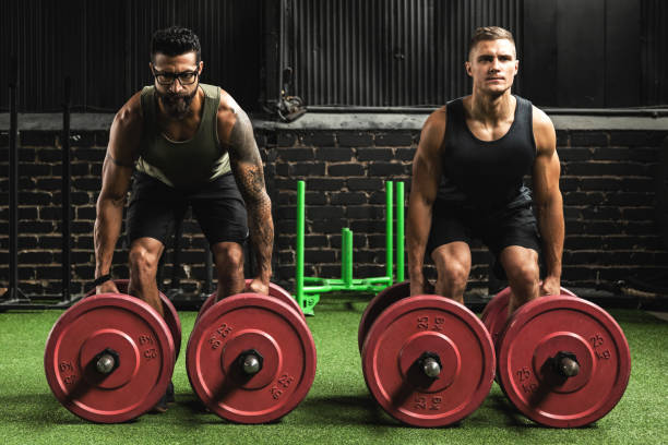 Muscular men during competition in the farmer's walk exercise