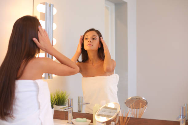 istock Attractive young woman applying cream on her Face 1083006146