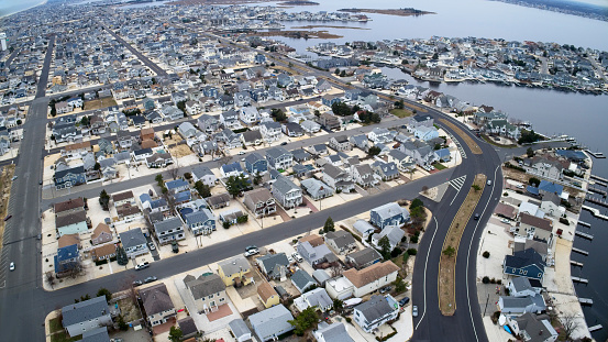 Aerial view of New Jersey shore town, looking south toward Barnegat Bay right and Atlantic Ocean on left with West Point Island far right. Shot from a DJI Phantom4 Pro drone.