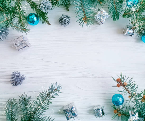 istock Christmas tree branch, blue ball, gift, cone on white wooden background 1083023676