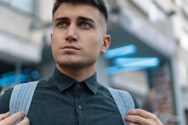 istock Portrait young man on blurred city background 1083028656