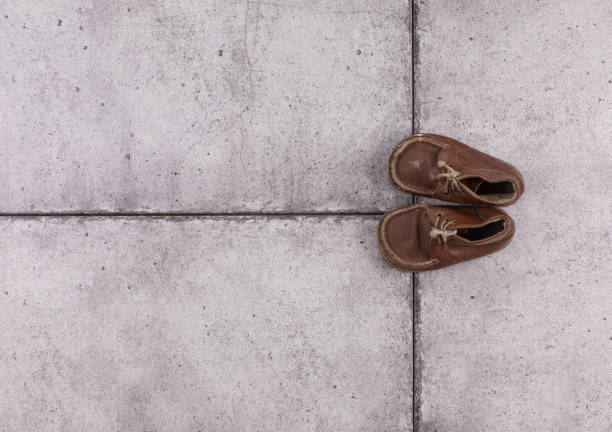 Man in stylish sneakers standing on asphalt, top view. Space for text