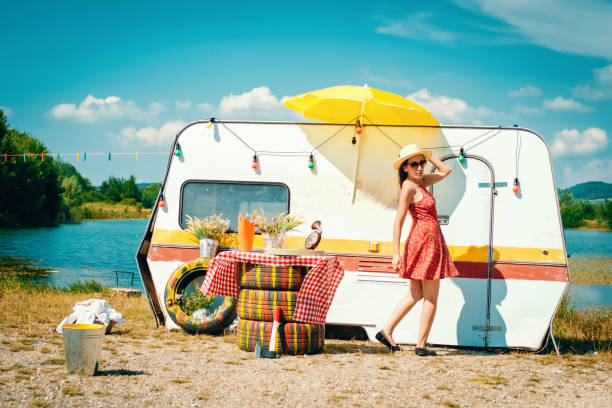 debout femme hippie à côté de la remorque de voiture - vehicle trailer flash photos et images de collection